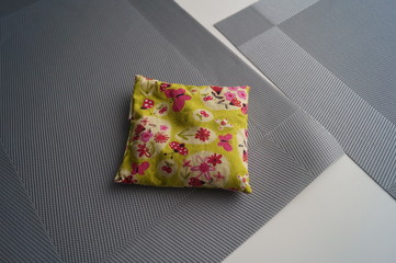  Small pillow on a white table. Cuddly miniature pillow