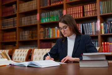 The girl student in the library does homework