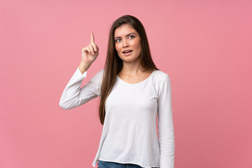 Young woman over isolated pink background intending to realizes the solution while lifting a finger up