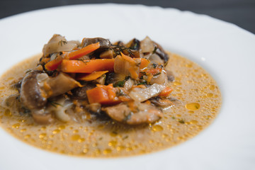 Plate with delicious mushrooms with creamy sauce on wooden background