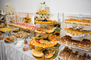 Delicious sweets on wedding candy buffet with desserts, cupcakes,tiramisu and cookies