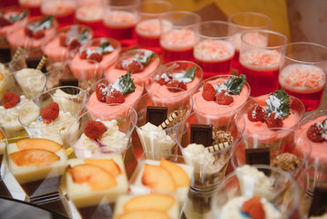 desserts with fruits, mousse, biscuits. Different types of sweet pastries, small colorful sweet cakes, macaron, and other desserts in the sweet buffet. candy bar for birthday
