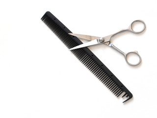 hairdresser professional scissors and black hairbrush comb isolated on white background close up