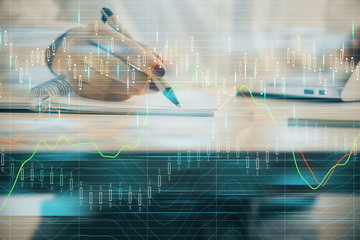 Double exposure of woman's hands making notes with forex graph hologram. Concept technical analysis.
