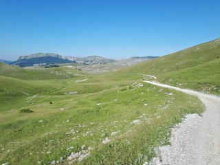 Rural road in the mountains with view of distant mountains	