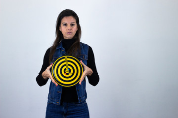 serious  middle age woman with dart board, long face, with a serious look on his face, isolated on gray background studio shotblack sweater, denim jacket, jeans. Place for your text in copy space.