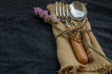 Rustic vintage set of wooden spoon and fork on black background.