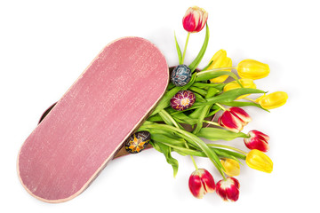 Bunch of beautiful yellow and red tulips and painted Easter eggs in oval box. Space for your text on the top of the box.