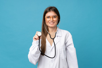Young woman over isolated blue background with doctor gown