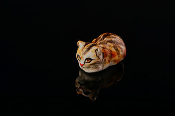 ceramic figurine of a cat on a black background