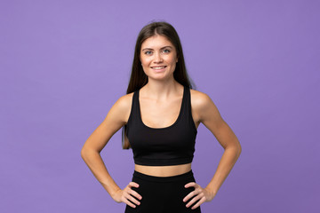 Young girl woman over isolated background posing with arms at hip and smiling