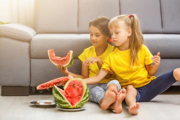 Two girls eating Watermelon isolated on home background