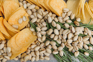 Beer snacks on craft paper. Assorted nuts and chips. Top view with copyspace black background