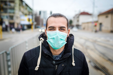 Young man with a medical face mask outdoor photo.Air pollution/ coronavirus protection concept.