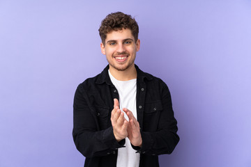 Caucasian man isolated on purple background applauding after presentation in a conference