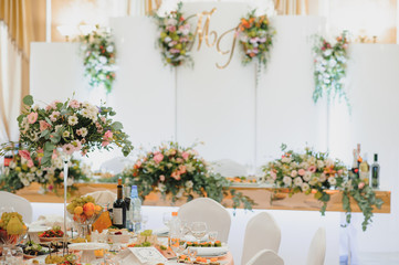 Floral wedding decoration. Wedding table setting decorated with fresh flowers. Wedding floristry. Bouquet with roses, eustoma and eucalyptus leaves.