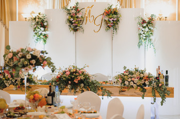 Floral wedding decoration. Wedding table setting decorated with fresh flowers. Wedding floristry. Bouquet with roses, eustoma and eucalyptus leaves.