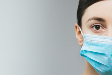 Woman with brown hair and a medical mask for protection again influenza. Copy space for your text....