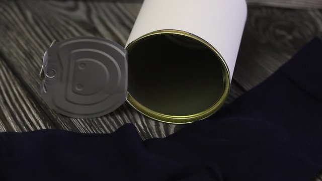 Men's socks in a gift tin can. An open jar lies on its side, next to its socks.