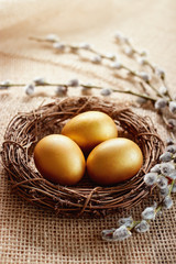 Golden Easter eggs in nest with pussy willow.