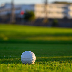Excellent well-kept green grass lawn on large golf course, green section with big white foam ball for beginners on Tenerife island, Canary, Spain