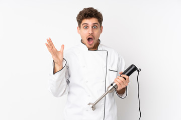 Man using hand blender isolated on white background with surprise facial expression