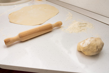 Wooden rolling pin and dough on a white background