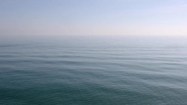 View of a stone beach with a clean transparent water and relaxing waves