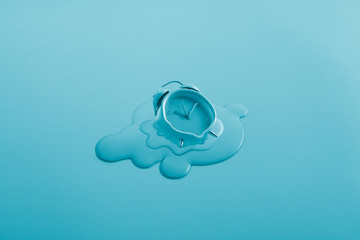 melting alarm clock in aqua blue background, minimalism, idea, conceptual images, can easily change the colour tone, and text as a design.