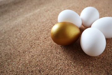 Fototapeta na wymiar Golden and white eggs lie on the table in the form of a flower. Happy easter concept, copy space.