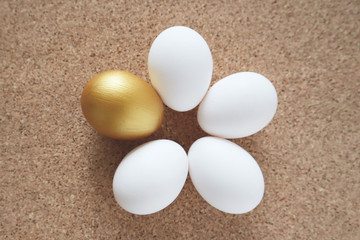 Golden and white eggs lie on the table in the form of a flower. Happy easter concept, top view.