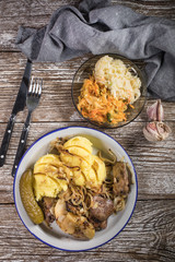 Fried liver with onion and apple, served with boiled potatoes and pickled cucumber.