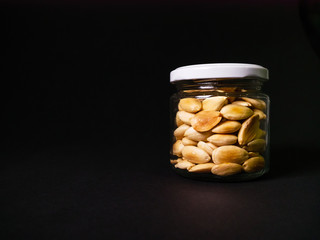 Almonds, jar with almonds on black background healthy eating raw food