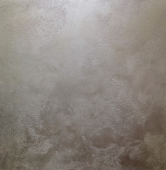 The gray texture of the wall is decorative plaster. Decorative wall covering - metallized sand