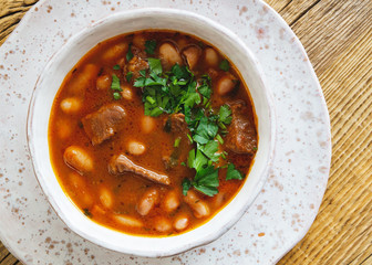 beans stew with meat, tomatoes, carrots, onion and garlic decorated with parsley
