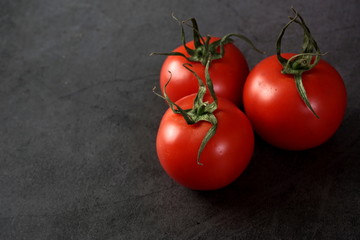 Ripe tomatoes on a dark background