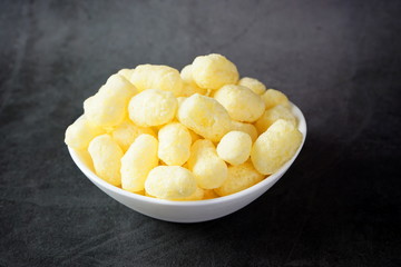 Corn sticks in a bowl on a dark background