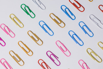 multicolored paper clips on a white background