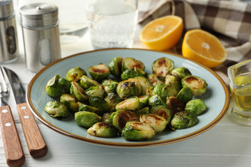 Composition with plate of brussels sprout on wooden background, close up