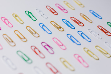 multicolored paper clips on a white background