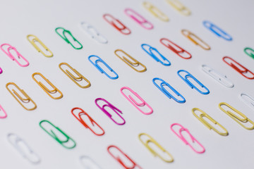 multicolored paper clips on a white background