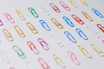 multicolored paper clips on a white background