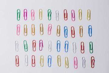 multicolored paper clips on a white background
