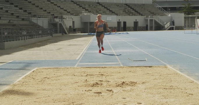 Front view of caucasian athlete doing long jump