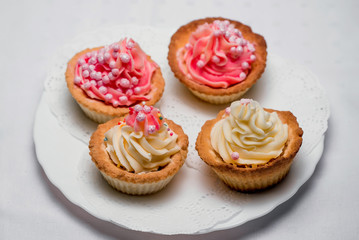 cute cupcakes with cream on a plate close-up