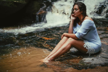 Portrait of a young woman in the waterfall