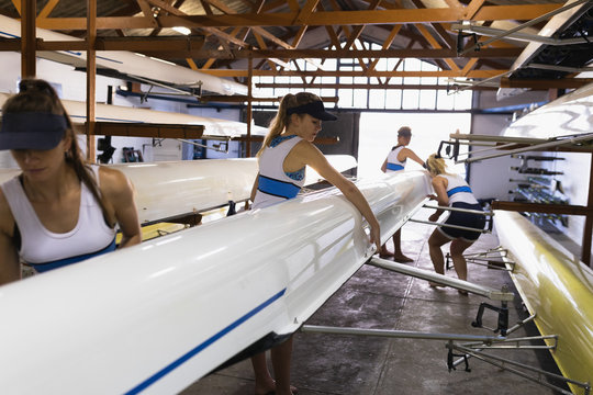 Female rowing team training on a river - Powered by Adobe