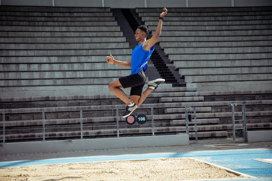 Athlete doing a long jump - Powered by Adobe
