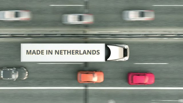 Trailer trucks with MADE IN NETHERLANDS text driving along the road. Dutch business related loopable 3D animation