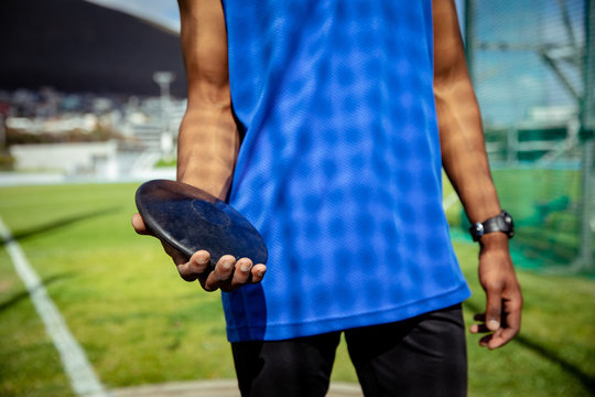 Athlete carrying a disk at the stadium